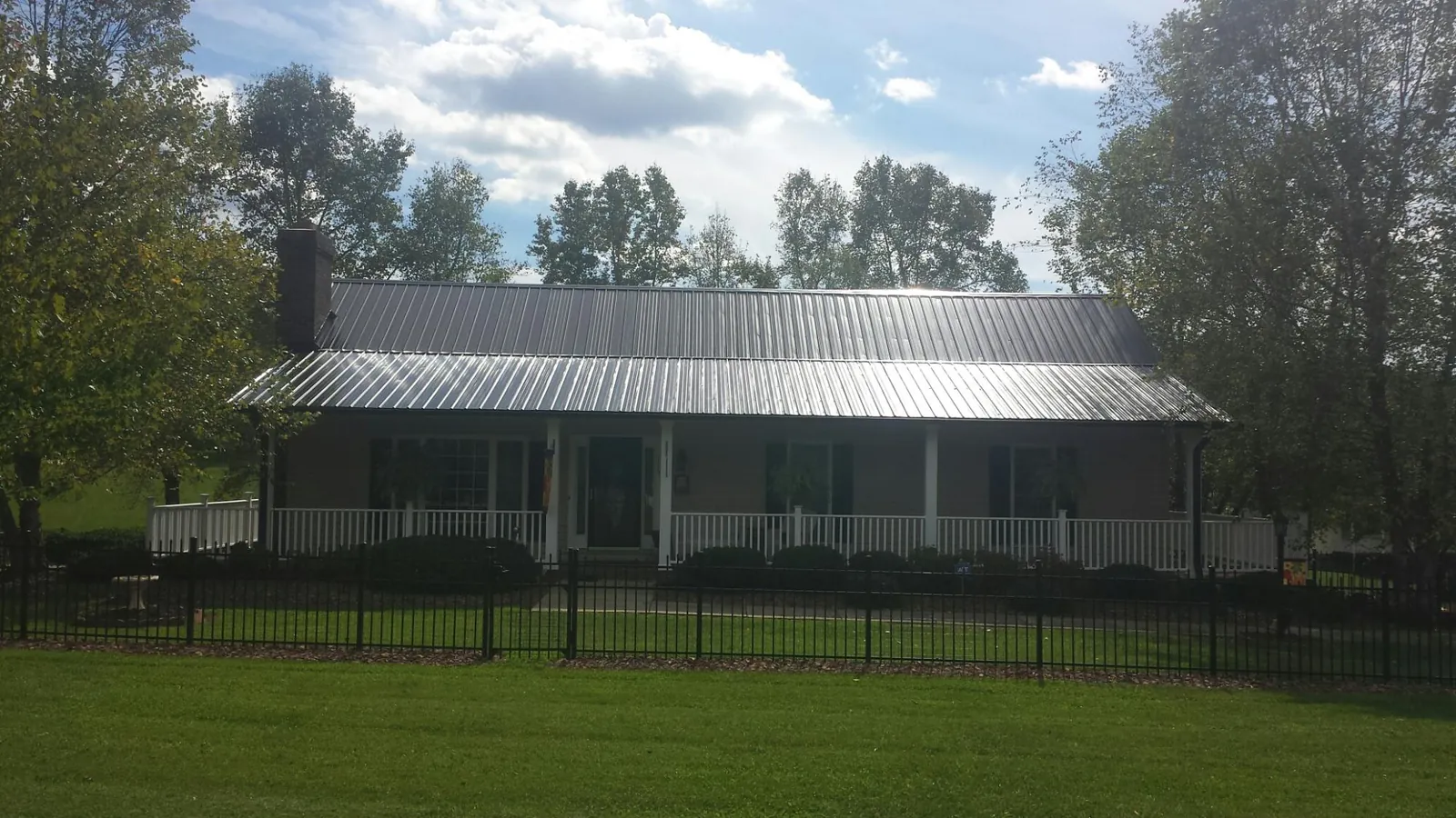Gray metal roof on a brick ranch with a full width front porch — Gutter Guard Installation work by our crew in Fargo